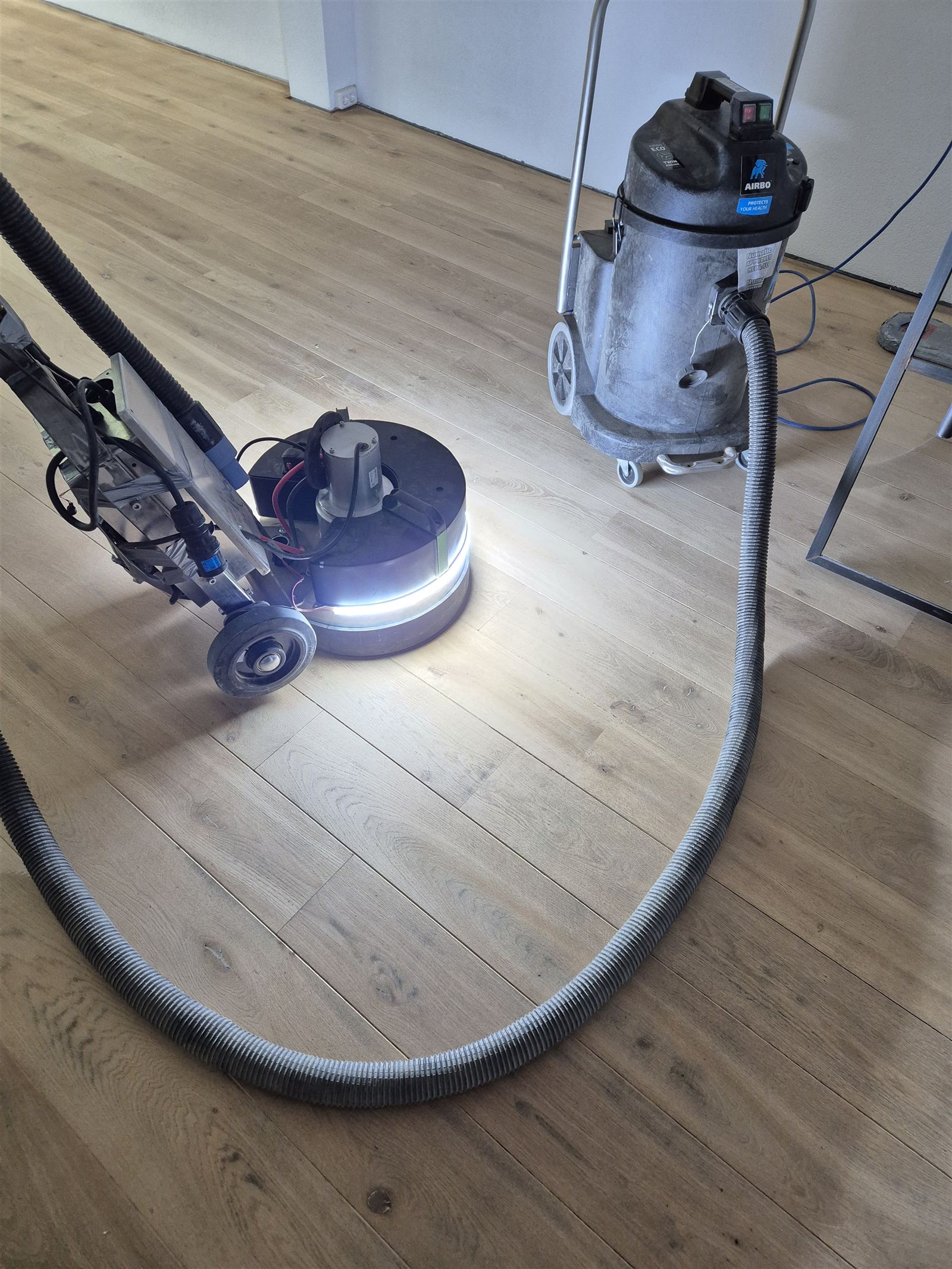 Kiwi cordless prototype sanding a wooden floor with dust extraction